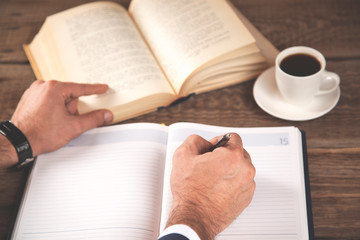 Naklejka premium man hand notepad with book and coffee