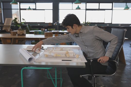 Architect working over model house in office