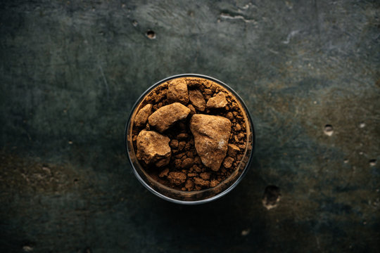 Glass jar full of brown soil