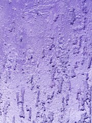 Fototapeta na wymiar The texture of the part of the old wall with rough plaster purple