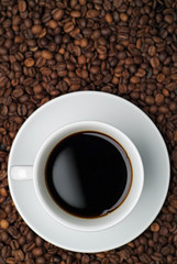 Cup of coffee against a background of coffee beans
