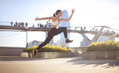 Fototapeta na wymiar Sportive girl jumping high in the street
