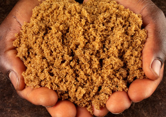 MAN HOLDING DARK RAW BROWN SUGAR