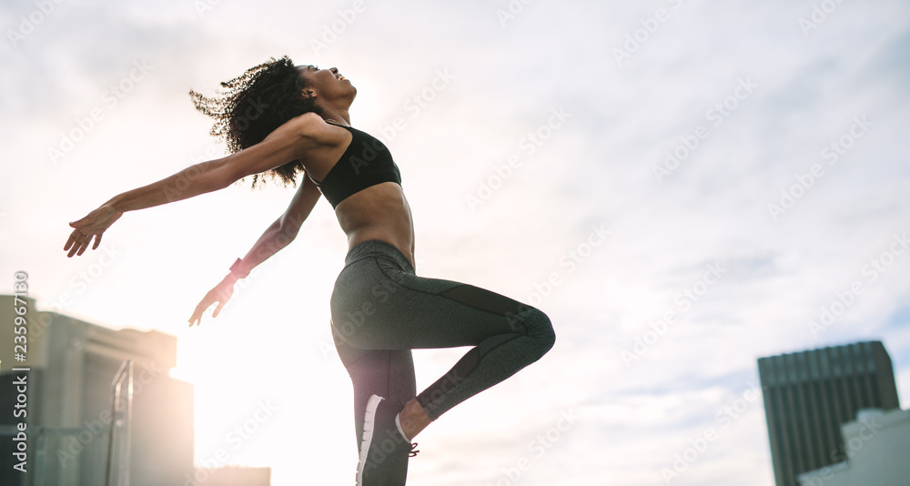 Wall mural Fitness woman doing work out on rooftop - Wall murals