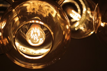 classic edison bulb in a transparent glass ceiling on a black background..concept: cafe interior design element