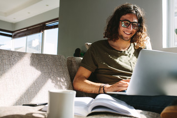 Smiling student studying on a laptop