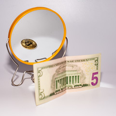 five dollar bill is reflected in the mirror.