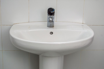 Lavabo/ un lavabo blanco visto de cerca con un fondo de azulejos detrás