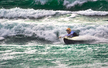 Kayaker surfa le onde nel Mar Mediterraneo.
