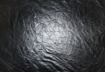 Texture of a silver reflector for photography, abstract background. Dark vignette.