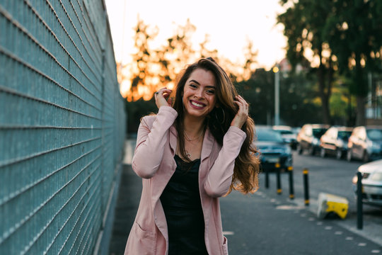 Young smiling woman in casual wear walking on street - Powered by Adobe