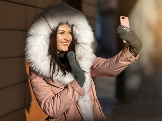 girl in a jacket with a hood talking on phone