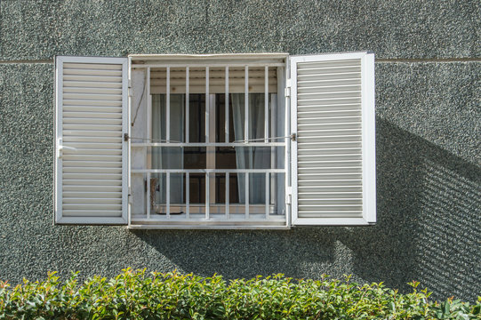 Ventana/ ventana con reja y contraventana en la fachada de un edificio de viviendas en Madrid. Espa&ntilde;a.