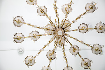 Large decorative golden chandelier in entrance hall of building.