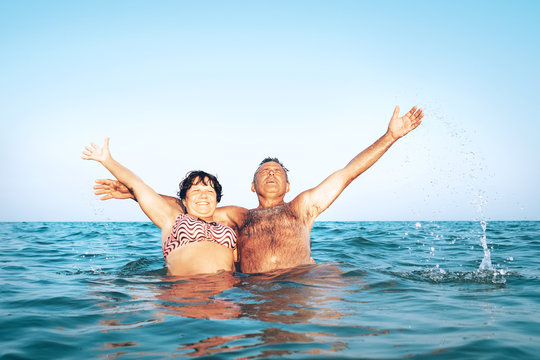 A happy caucasian senior couple enjoys their sea vacation on the beach