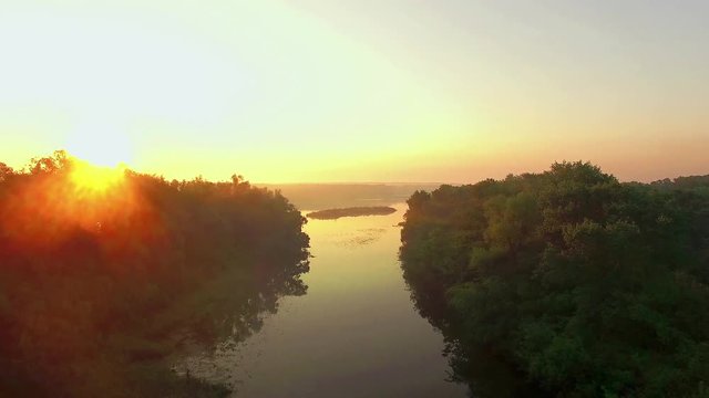 aerial view of river at sunrise 4K, fly over morning mist on the river, Very high view of the river at sunrise, Aerial view of mystical river at sunrise with fog, sun above the river aerial