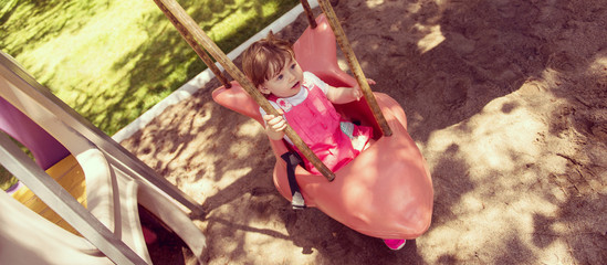 little girl swinging  on a playground