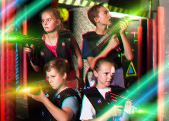 Obraz na płótnie Canvas Girls and boys posing with laser pistols