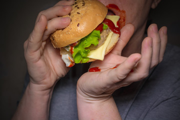 Woman smeared her face with ketchup eating a hamburger