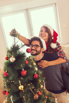 Couple decorating Christmas tree