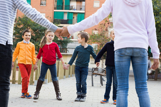 Group of cheerful children playing red rover