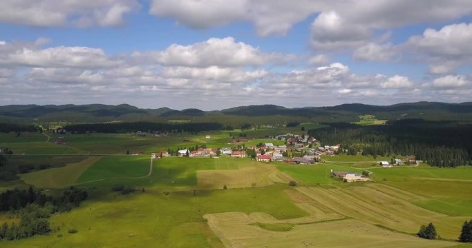Aerial, time lapse, drone shot, of a small town in the french countryside, cloud shadows reflecting on the ground, , in Chapelle des bois, Doubs and Jura regional park, Franche comt&radic;&copy;, in France