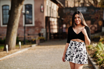 Naklejka premium Pretty latino model girl from Ecuador wear on black tops and skirt posed at street.