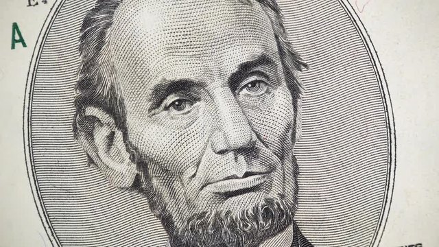 US President Abraham Abe Lincoln on United States 5 dollar bill rotating. 4K UHD video footage