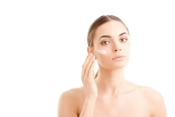 Obraz na płótnie Canvas Woman applying cream onto her face against white background, Studio beauty shot