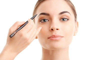 Woman applying makeup against white background, Studio beauty shot