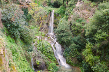 Fototapeta na wymiar Waterfall in Gregorain villa in Tivoly, small town near Rome. Shot on long exposure.