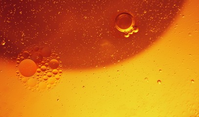 Yellow bubbles and drops of oil and water, beer and beverage texture background.