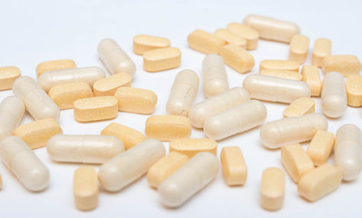 Medicine yellow pills or capsules on a white background close-up. vitamins Drug prescription of drugs for treatment. Pharmaceutical drug, cured in a container for health. Antibiotic drugs.