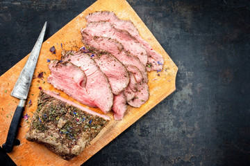 Traditioneller bayrischer Brotzeit Aufschnitt  mit Rostbraten Scheiben als Draufsicht auf einem Schneidebrett mit Textfreiraum rechts