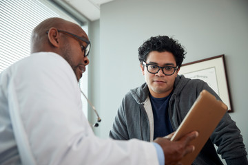 Fototapeta premium Doctor talking to boy in examination room