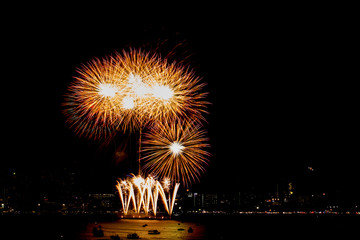 Many flashing fireworks with night cityscape background celebrate New Year.