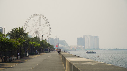 Quay near the Mall of Asia. Panorama Manila city, skyscrapers and buildings. Seascape coastal city of Manila. Modern city by sea. Makati district. Travel concept.
