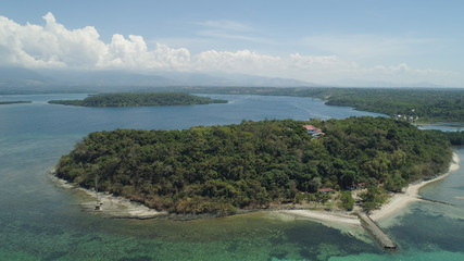 Tropical island with white sandy beach. Aerial view: Magalawa island with colorful reef. Seascape, ocean and beautiful beach paradise. Philippines,Luzon. Travel concept.