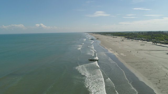 Aerial view of sandy beach Lingayen with fishermen using nets for fishing on the island Luzon, Philippines. Seascape, ocean and beautiful beach.