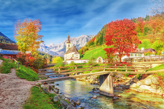 Captivating autumn scenery of Alpine river Ramsauer Ache, mountains Alps, Great view on Parish Church of St. Sebastian in Germany, Bavaria, Europe. Ramsau, Berchtesgaden National Park, German Bayern.