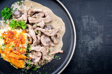 Traditional Swiss zürcher geschnetzeltes with rösti as top view on a modern style plate with copy space right