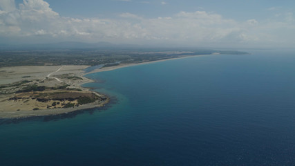 Aerial view of seashore with beaches, lagoons and coral reefs. Philippines, Luzon, Ilocos Norte. Coast ocean with turquoise water. Tropical landscape in Asia.