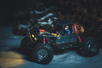Obraz na płótnie Canvas radio-controlled car in the snow at night, lights shine. Christmas present rc car