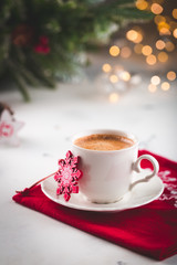 Cup of espresso or americano coffee in white cup in cozy Christmas arrangement, festive decoration with bokeh background, copy space