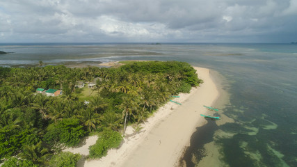 Aerial view of beautiful tropical beach with turquoise water in blue lagoon, Punta verde, Philippines, Santa Ana. Ocean coastline, mountains covered rainforest. Tropical landscape in Asia.