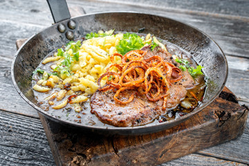 Traditioneller bayrischer Zwiebelrostbraten mit Röstzwiebel und schwäbischen Spätzle als closeup...