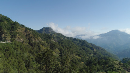 Fototapeta na wymiar Aerial view of mountains covered forest, trees in clouds. Cordillera region. Luzon, Philippines. Slopes of mountains with evergreen vegetation. Mountainous tropical landscape.
