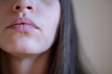 Beautiful girl grimacing in front of the mirror. Cosmetic procedures. Close-up. Selective focus,...