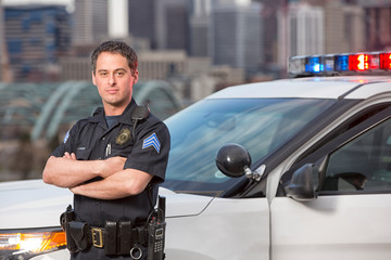 Police sergeant leaning agains car - obrazy, fototapety, plakaty