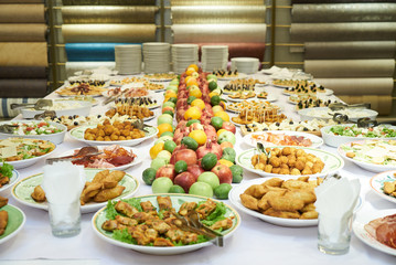 Catering table set service with cold snacks, canapes, fruits and